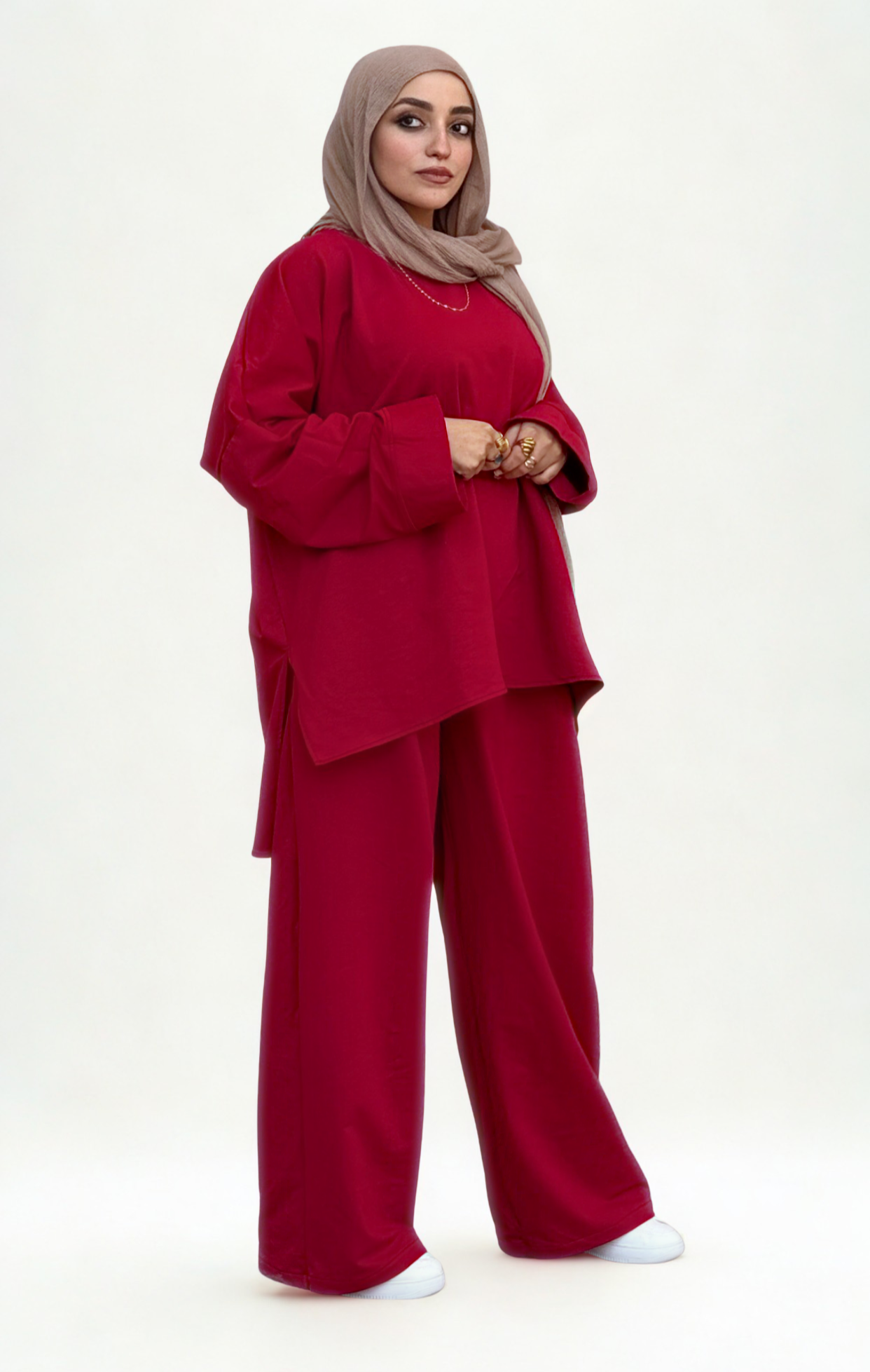 Woman wearing a red outfit with a hijab on a white background