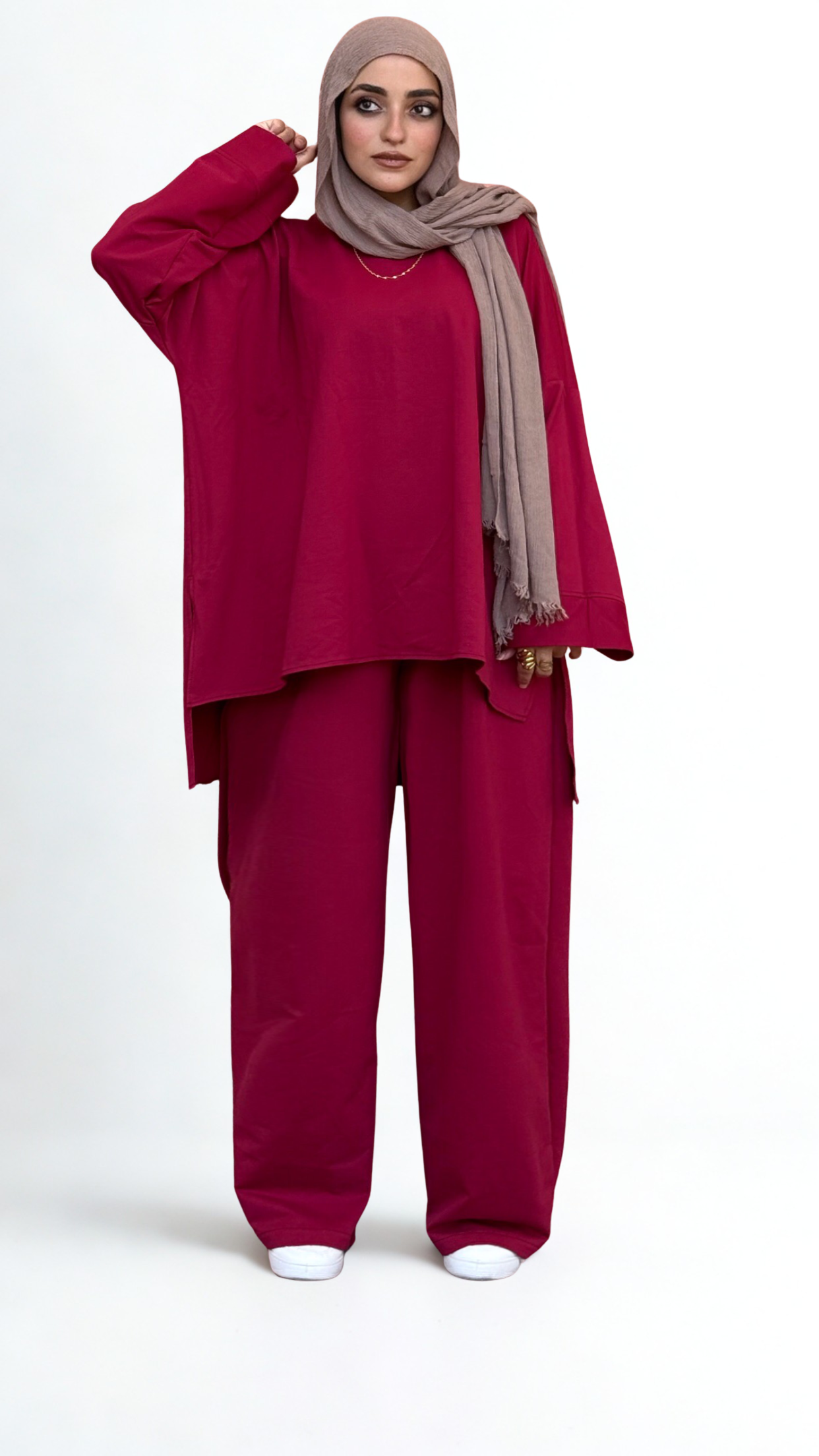 Woman wearing a red outfit with a beige hijab on a white background