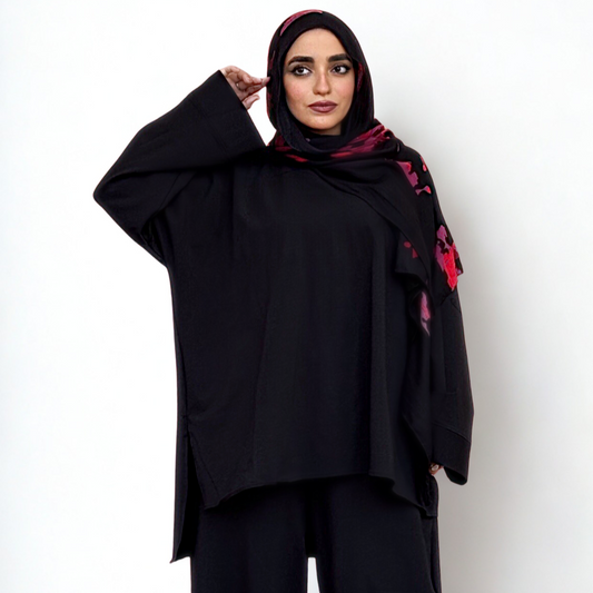 Person wearing a black outfit with a matching hijab on a white background