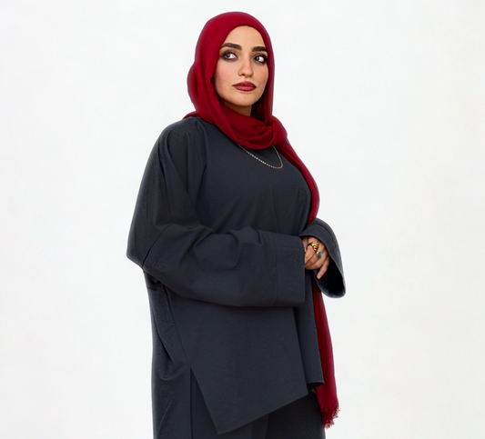 Woman wearing a dark outfit with a red hijab on a white background